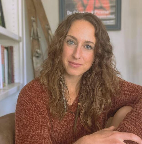 a photo of Arielle with books, skis, and a Picasso portrait in the background